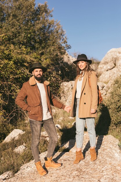 Young couple holding hands and looking at photographer