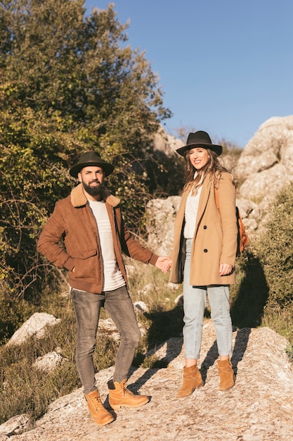 Young couple holding hands and looking at photographer