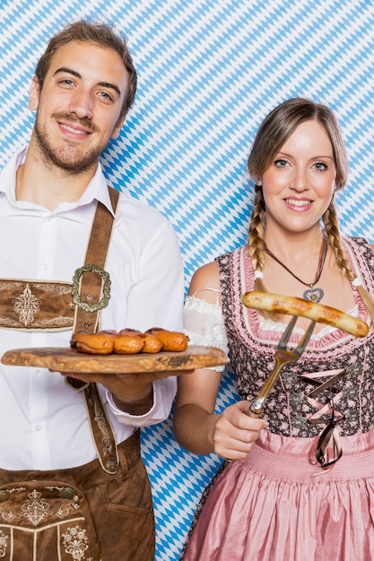 Foto gratuita giovani coppie che tengono gli spuntini più oktoberfest