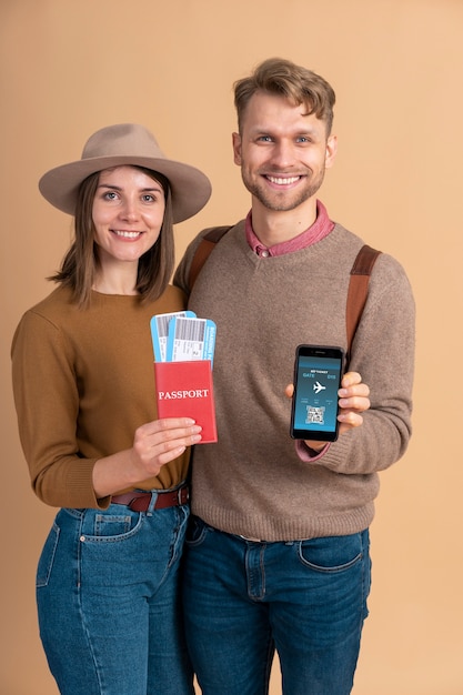 Young couple holding smartphone and plane tickets for traveling