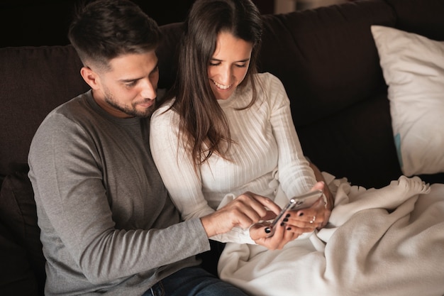 Young couple at home looking on mobile