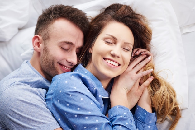 Young couple hugging in bed at the morning