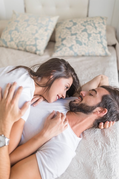 Young couple hugging on bed