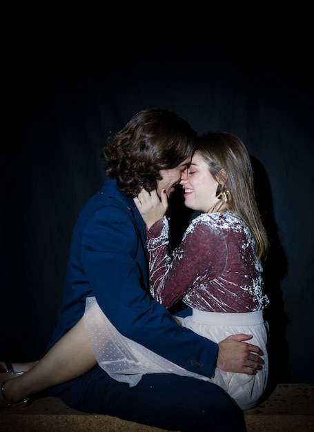 Free photo young couple hugging on bench