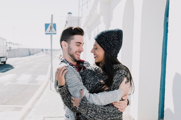 Young couple hugging each other next to road