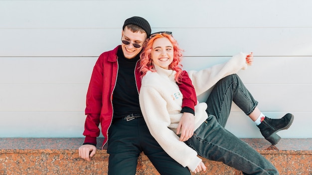 Young couple hugging and laughing while sitting on street bench