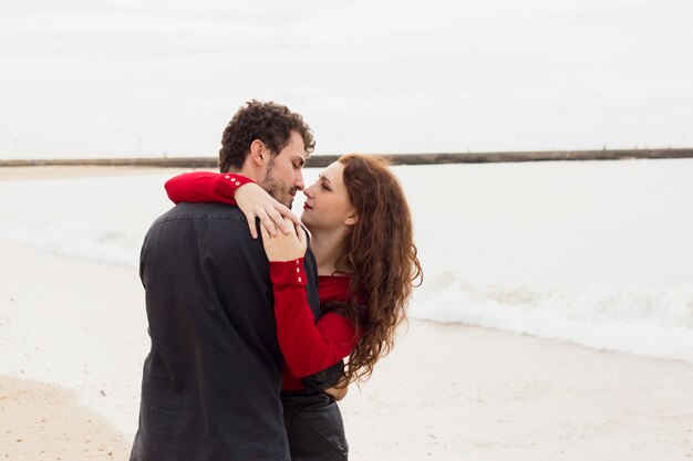 Молодая пара обниматься на берегу моря