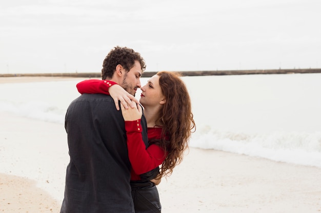 Young couple hugging on sea shore 