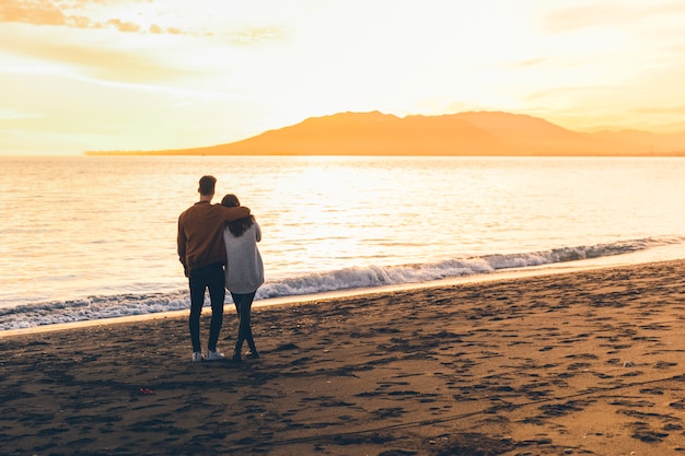 Young couple hugging on sea shore 