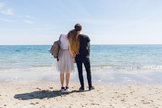 Молодая пара стоит у моря
