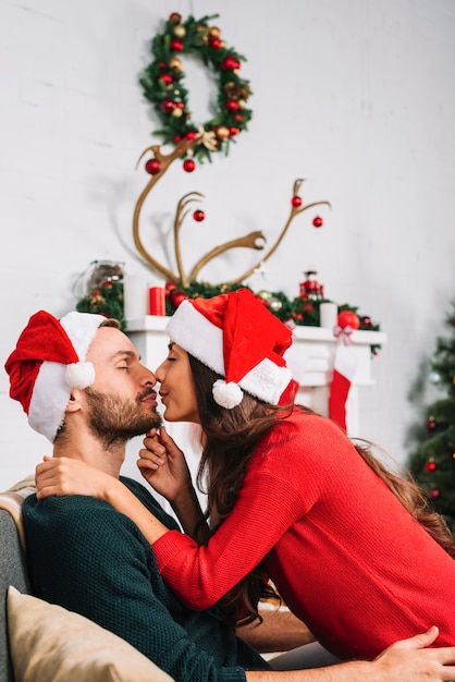 Free photo young couple kissing on sofa