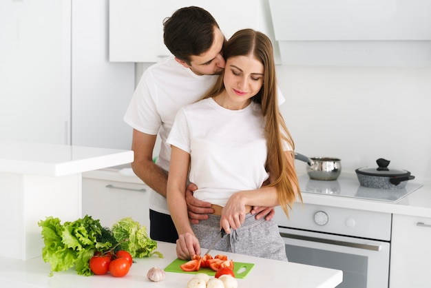 Free photo young couple in kitchen cooking