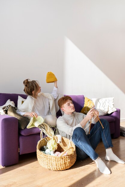 Young couple knitting together