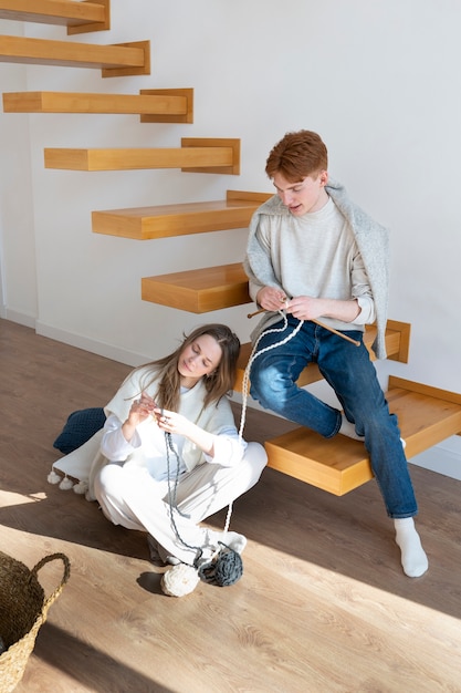 Young couple knitting together