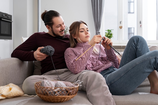 Young couple knitting together