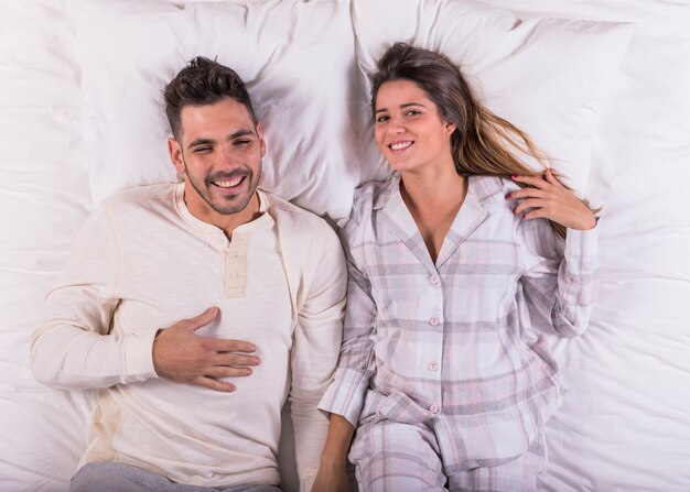 Young couple laughing in bed 