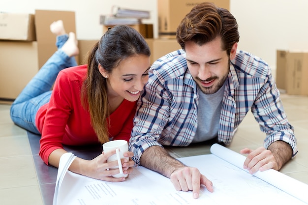 Young couple looking at the blueprints of their new home