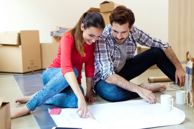 Young couple looking at the blueprints of their new home