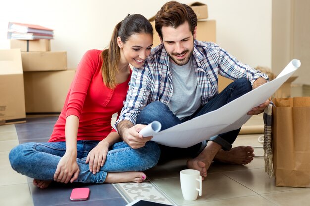 Young couple looking at the blueprints of their new home