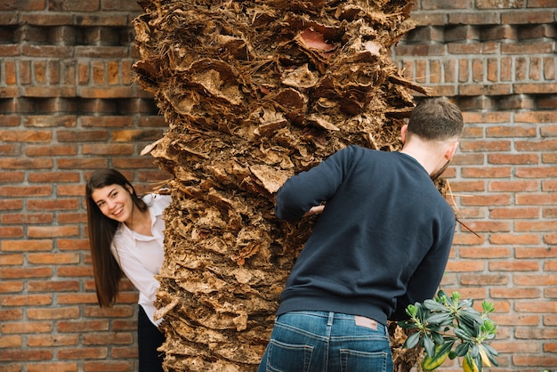 Giovane coppia in amore intorno all'albero