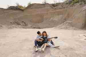 Foto gratuita giovane coppia innamorata, ragazzo a suonare la chitarra
