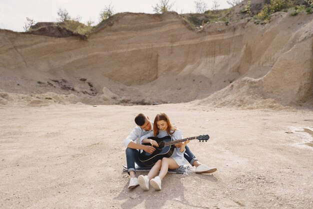 Молодая влюбленная пара, парень играет на гитаре