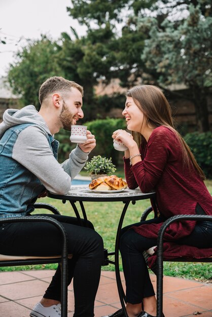 Молодая пара в любви пить кофе в саду