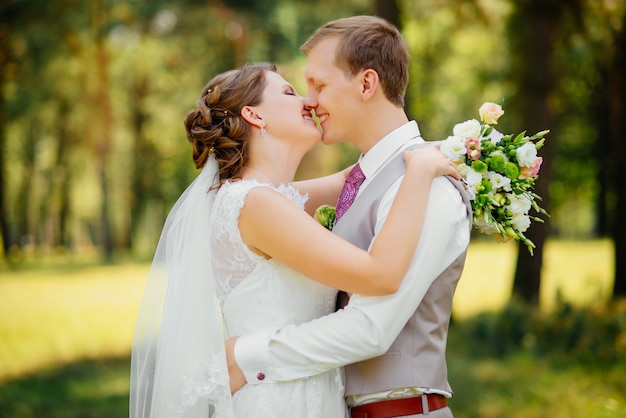 Young couple in love, groom and bride in wedding dress at the nature. Wedding.