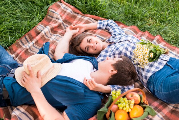 Young couple in love lying together on blanket