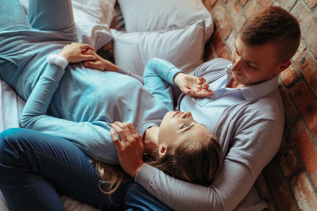 Young couple in love spending time together. Beautiful woman and handsome man having intimate moments at home