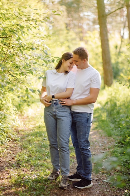 A young couple in love walks in the woods, having a good time together