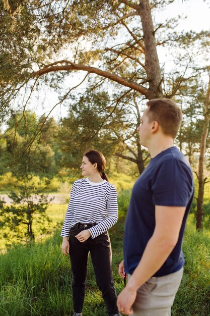 A young couple in love walks in the woods, having a good time together