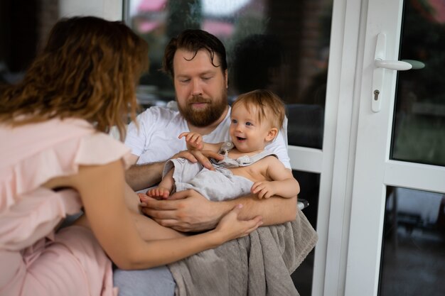 young couple in love with a small child on the terrace of his house.