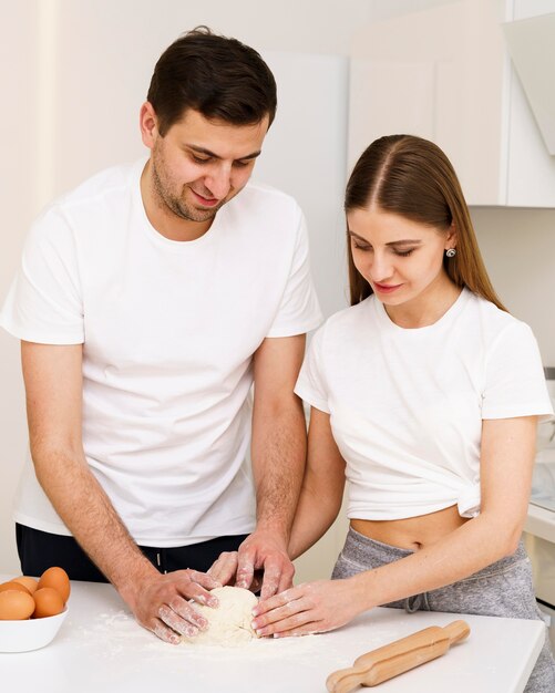 Молодая пара делает тесто