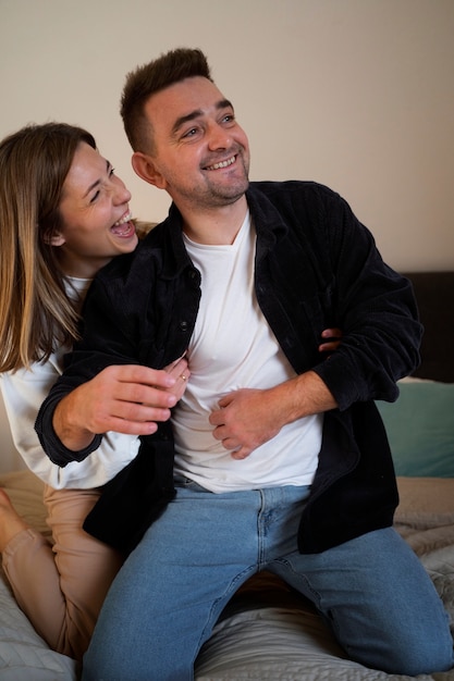 Free photo young couple making each other laugh by tickling