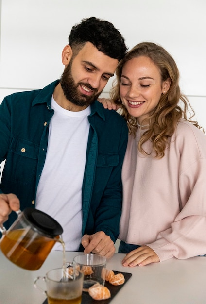 Free photo young couple making tea at home together