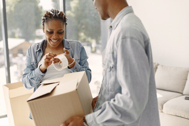 Young couple moving in to new home together. African american couple with cardboard boxes.