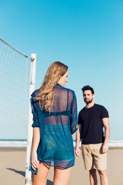 Young couple near volleyball net