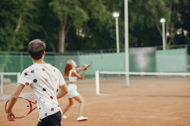 Молодая пара на теннисном корте. два теннисиста в спортивной одежде.