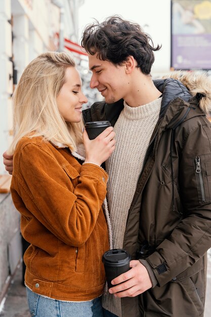 Free photo young couple outdoor enjoying cup of coffee