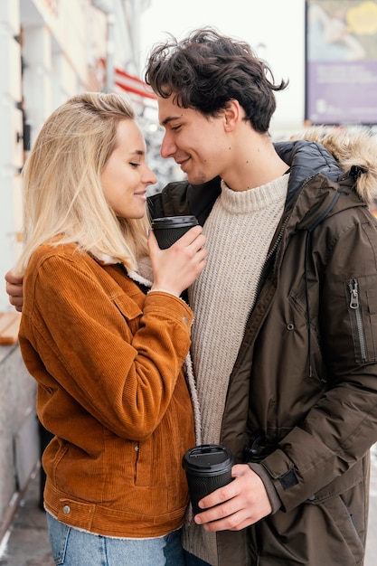 Young couple outdoor enjoying cup of coffee