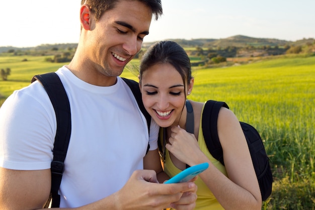 young couple outdoors looking at the mobile phone