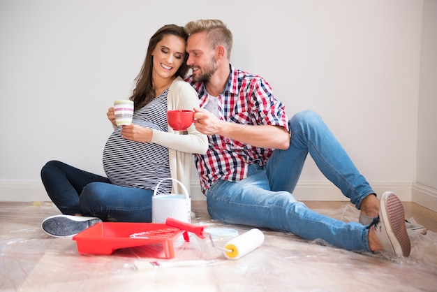 Young couple painting walls and drinking coffee