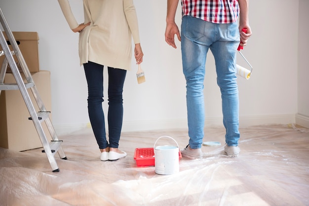 Free photo young couple painting walls