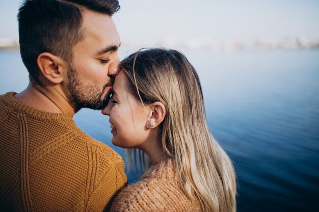 Young couple in park standing by the river