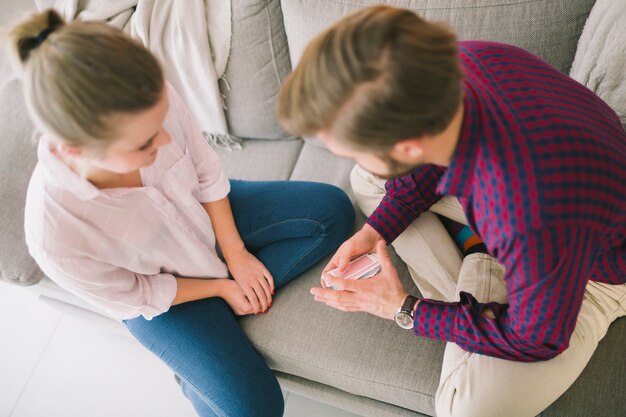 Young couple playing cards on sofa