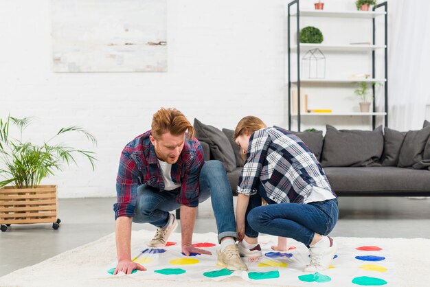 Young couple playing the color dot game in the living room at home