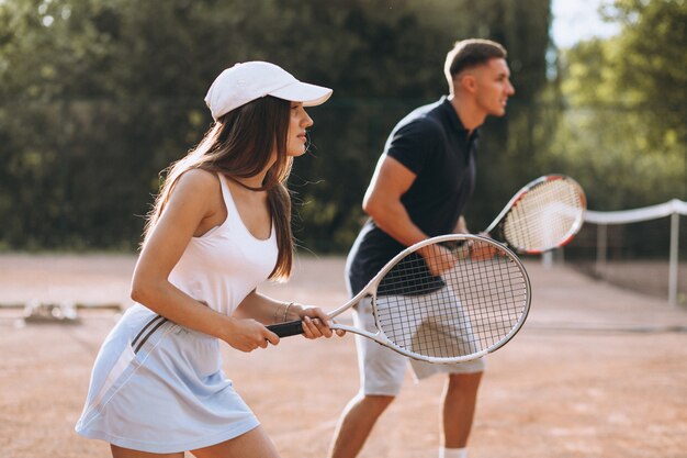 Young couple playing tennis at the court