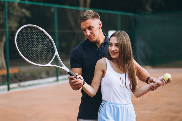 コートでテニスをしている若いカップル