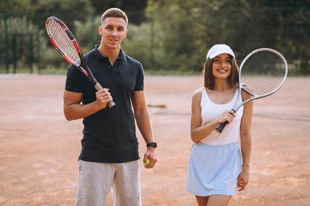 Young couple playing tennis at the court